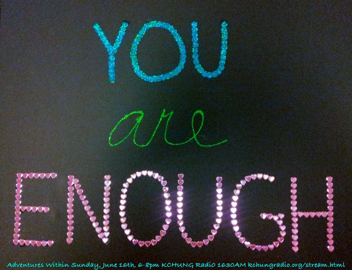 A sign written in glitter that reads, YOU are ENOUGH