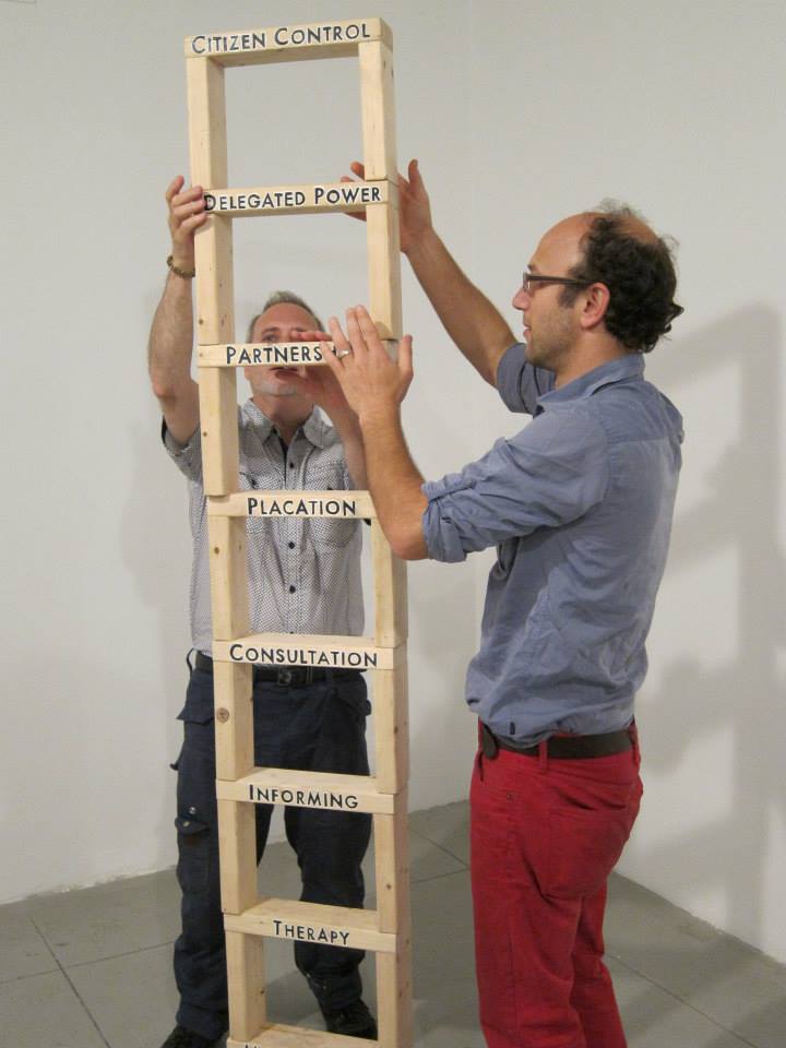 photo of Robby Herbst working with another person to construct the Ladder of Citizen Participation for his I & We: Collective Movement Workshop