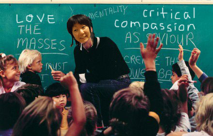 photo of Jennifer Moon as a teacher in a classroom full of children